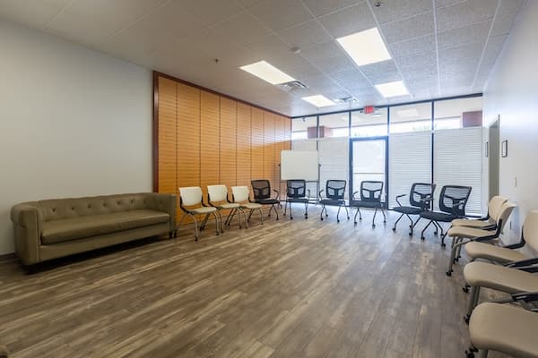 Brightly lit clean room at Oxford Southaven with a circle of chairs and wood floors