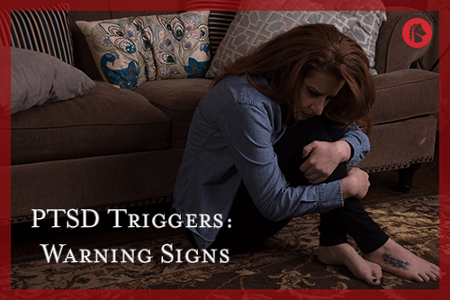distressed woman with ptsd holding herself and staring at the floor