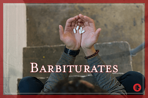 man holding pills of barbiturates