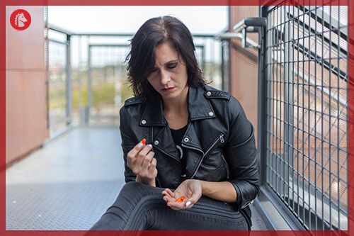 woman with a few orange pills in her hands