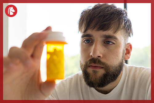 man staring at bottle of antidepressants