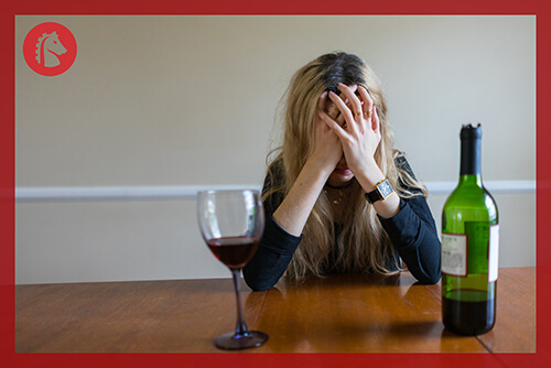 woman with hands on head because of alcohol withdrawal