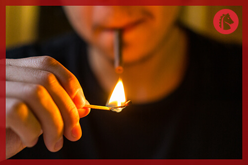 man putting match up to smoke cocaine