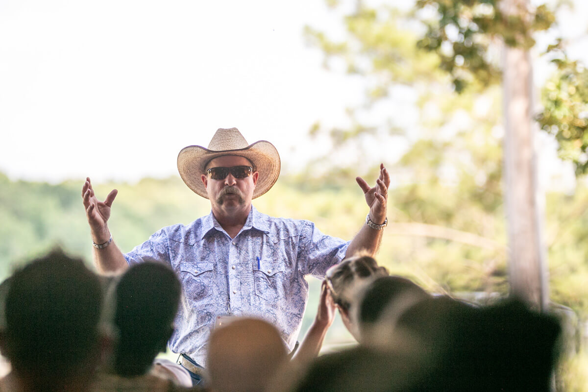 Man in cowboy hat talks to crowd
