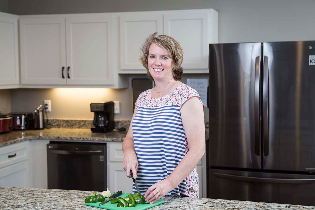 Meriwether Shelton, RDN, LD in a kitchen chopping a green bell pepper